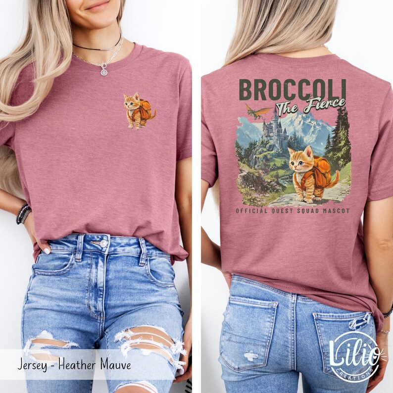 May include: A heather mauve t-shirt with a small image of a cat wearing a backpack on the front. The back of the shirt has a graphic of a cat wearing a backpack in a mountain scene with the text "Broccoli The Fierce" and "Official Quest Squad Mascot".