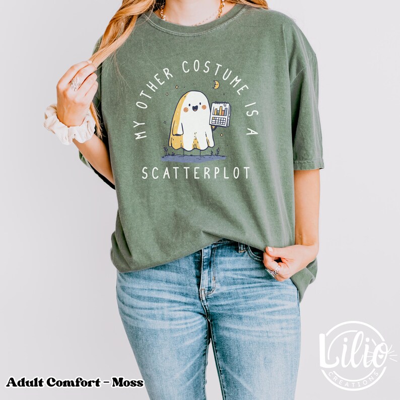Pode incluir: T-shirt verde musgo com o texto "MY OTHER COSTUME IS A SCATTERPLOT". O design apresenta um fantasma de desenho animado segurando um gr&aacute;fico. A t-shirt &eacute; feita de um material macio e confort&aacute;vel.