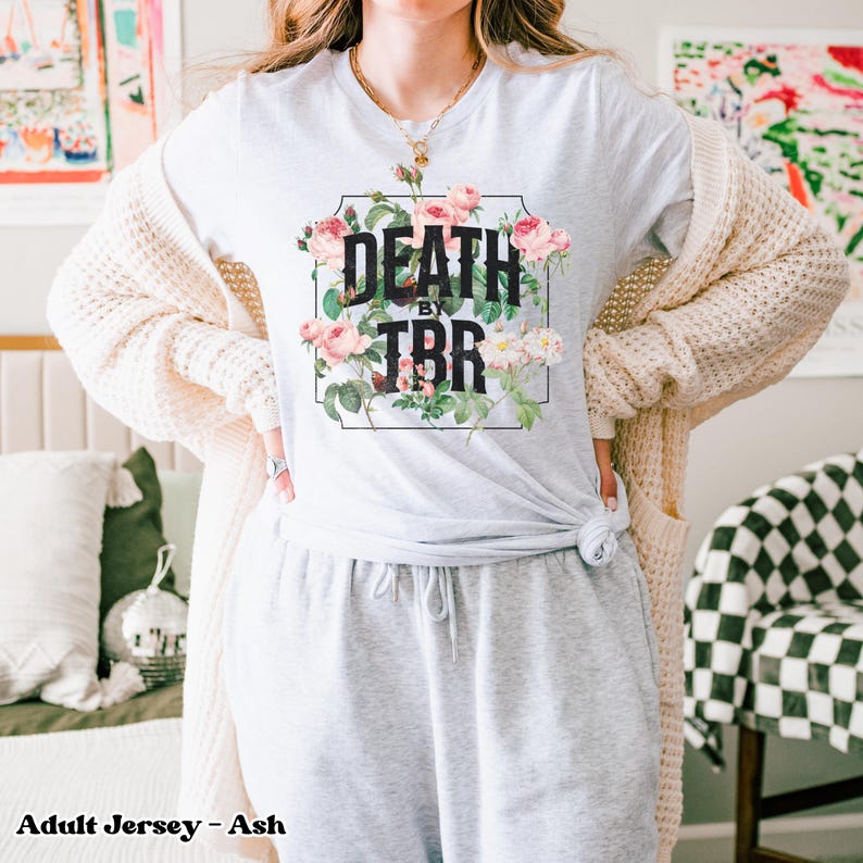 May include: A gray adult jersey t-shirt with a floral design and the text "Death by TBR" printed on the front.