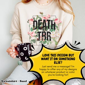 May include: A sand-colored sweatshirt with a floral design and the text "DEATH BY TBR". The sweatshirt is being held by a person. A speech bubble with the text "LOVE THIS DESIGN BUT WANT IT ON SOMETHING ELSE? Just send me a message! I'm happy to offer any of my designs on whatever product or color you're looking for!" is in the lower right corner of the image.