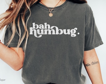 Könnte beinhalten: Ein dunkelgraues T-Shirt mit dem Text "bah humbug." in weiß gedruckt.