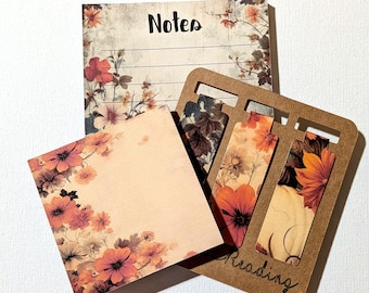 Può includere: Un set di cancelleria composto da un blocco note con la parola Notes, un blocco di foglietti adesivi quadrati e un supporto in legno marrone contenente tre segnalibri con motivi floreali e la parola Reading incisa sul telaio.