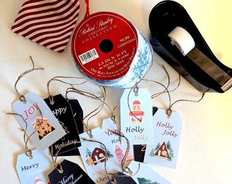 Può includere: Un sacchetto con coulisse a righe rosse e bianche, un rotolo di nastro Robert Stanley Christmas Collection da 6,35 cm per 9,14 m, un dispenser di nastro adesivo nero e diverse etichette regalo con illustrazioni e testo natalizio.