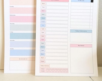Può includere: Un'agenda settimanale e un'agenda giornaliera stampate su carta bianca. L'agenda settimanale presenta righe color pastello per ogni giorno e una lista della gratitudine. L'agenda giornaliera include un programma dalle 6:00 alle 22:00, una lista di cose da fare, una sezione motivazionale, note e un tracker per l'assunzione di acqua con otto icone di bicchieri.