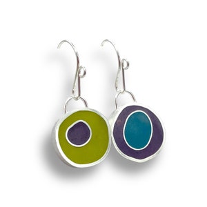 May include: A pair of silver dangle earrings with round resin charms. The charms are layered with purple, teal, and yellow resin.