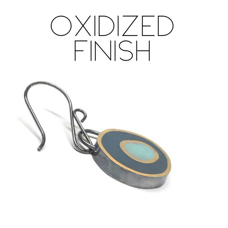 May include: Oxidized finish silver earring with a blue and gold circle pendant.