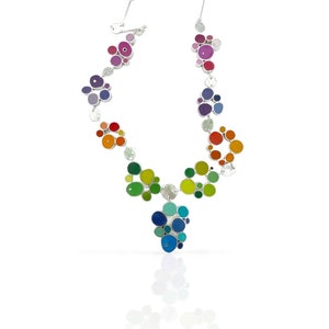 May include: A silver necklace with a rainbow of colorful enamel circles. The circles are of varying sizes and are connected by silver links. The necklace is on a white background.