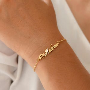 Peut inclure: Bracelet en or avec le nom "Andrew" écrit en cursive.