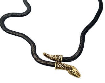 May include: A black snake chain necklace with two gold snake head charms.