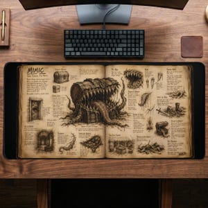 Puede incluir: Alfombrilla de escritorio rectangular negra con una ilustración detallada de un libro de fantasía. Las páginas del libro muestran dibujos de un cofre del tesoro con dientes y otros elementos de fantasía. La palabra "MIMIC" está en la parte superior.