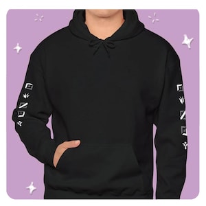 May include: Black hoodie with a front pocket and a drawstring hood. The sleeves feature a white and gray geometric design. The person is wearing the hoodie. The background is a light purple color with white star shapes.