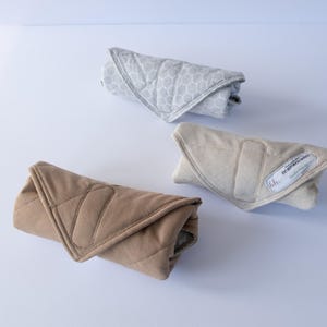 May include: Three rolled up baby swaddles in different colors and patterns. The swaddles are made of soft, breathable fabric and are designed to help babies sleep soundly. The swaddles are a great way to keep babies warm and cozy.