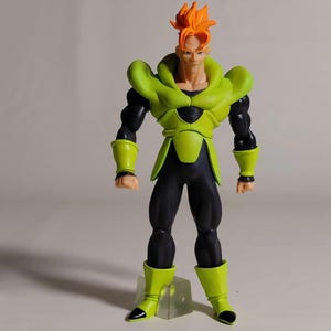 May include: A detailed action figure of a character with orange spiky hair, wearing a green and black outfit. The figure has a muscular build and stands on a clear base. The figure's design is reminiscent of a popular anime or manga series.