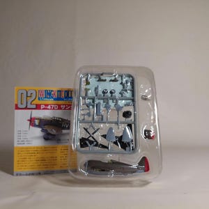 以下が含まれることがあります： P-47Dサンダーボルトの模型飛行機キット。 キットには、未組立部品が入ったプラスチックトレイ、完成したモデル、および「WING TOOL」と「P-47D」のテキストが入った箱が含まれています。 モデルはグレーで、赤と黒のアクセントが付いています。