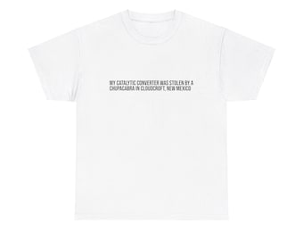 May include: White t-shirt with the text "MY CATALYTIC CONVERTER WAS STOLEN BY A CHUPACABRA IN CLOUDCROFT, NEW MEXICO" printed on the front.