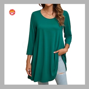 May include: A solid dark green tunic top featuring a round neckline and three-quarter length sleeves. The garment has a loose, flowing fit that extends past the waistline. A gold pendant necklace is worn around the neck with the shirt.