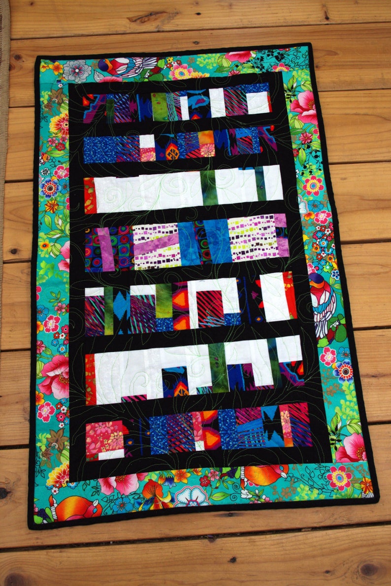 This unique, scrappy, quilt was made from the left over fabric of my last quilt. Bold and bright colors surrounded by a cheerful border. 20"x30.5"