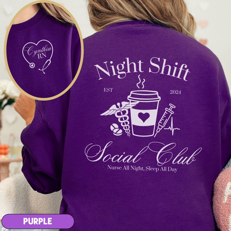 K&ouml;nnte beinhalten: Lilafarbener Pullover mit einem wei&szlig;en Grafikdesign, auf dem "Night Shift Social Club" mit einer Kaffeetasse, einem Stethoskop, einer Spritze und Pillen steht. Der Text "EST 2024" und "Nurse All Night, Sleep All Day" ist ebenfalls im Design enthalten.