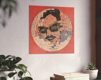 Op de afbeelding: Een vierkante muurposter met een cirkelvormige afbeelding van een persoon met een zonnebril waarop de tekst Harry Styles op de glazen staat. Het ontwerp heeft een verweerde, getextureerde esthetiek in tinten rood, beige, zwart en grijs.