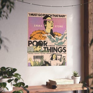 May include: A movie poster for the film "Poor Things" directed by Yorgos Lanthimos. The poster features a colorful, stylized image of Emma Stone, with the text "I must go punch that baby" above her. The poster also includes the names of the actors and the production company, Searchlight Pictures.