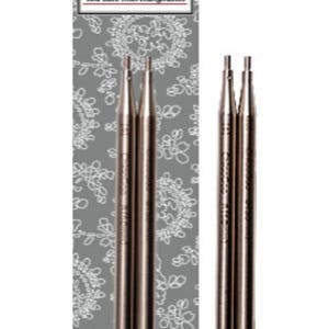 May include: A set of three silver Twist interchangeable knitting needles. The needles are packaged on a card with a white and gray floral pattern. The card has the text "Twist Red Lace Interchangeable" printed on it.