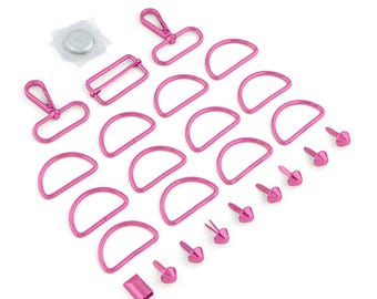 May include: A collection of pink metal bag-making hardware. Includes D-rings, rivets, rectangular sliders, swivel clasps, and a magnetic snap closure. The hardware is arranged on a white background.