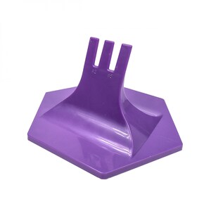 May include: Purple plastic display stand with three prongs on top and a hexagonal base. The prongs are labeled #2 and #5.