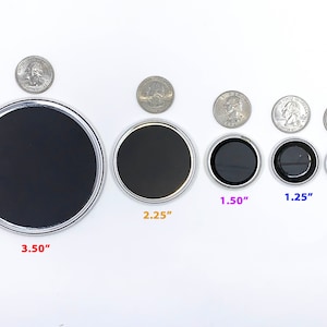 May include: A set of eight round, silver-rimmed magnets in various sizes, ranging from 1 inch to 3.5 inches in diameter. The magnets are arranged in order of size, with the largest magnet on the left and the smallest magnet on the right. The magnets are all black and have a smooth, glossy finish.