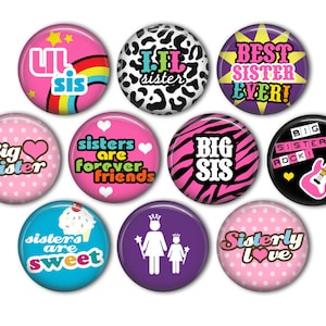 May include: Ten round pink, purple, blue, and black buttons with various sister-themed designs. The designs include "Big Sister", "Lil Sis", "Sisters are forever friends", "Sisters are sweet", "Best Sister Ever", "Big Sis", "Big Sisters Rock!" and "Sisterly Love".