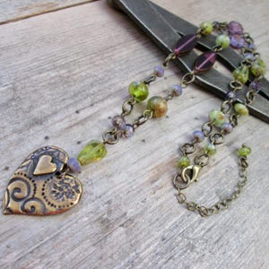 Collar de cuentas checas moradas y verde oliva: estilo bohemio vintage con colgante de corazón de latón antiguo.