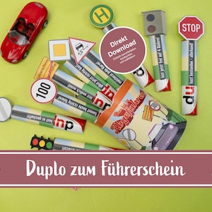 May include: A collection of toy traffic signs, a red toy car, and a container with the words "Abgefahren" and "Duplo zum Führerschein". The signs include a stop sign, a speed limit sign, and a traffic light.