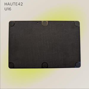May include: Black rectangular tablet computer with the text "HAUTE42 U16" on the top left corner. The tablet has four rubber feet on each corner.