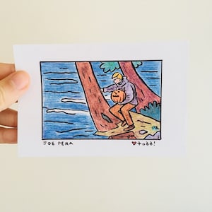 May include: A hand-drawn illustration of a person in a purple sweater holding a carved pumpkin, standing on a rock by a river. The text "JOE PERA" is at the bottom left and "&hearts; +odd!" is at the bottom right.