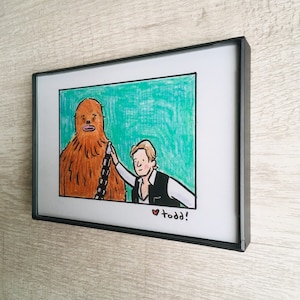 May include: A framed illustration of a brown Wookiee character from Star Wars with a human character standing next to it. The human character is wearing a brown vest and a white shirt. The background is a teal green color. The text "&hearts; todd!" is written at the bottom of the illustration.