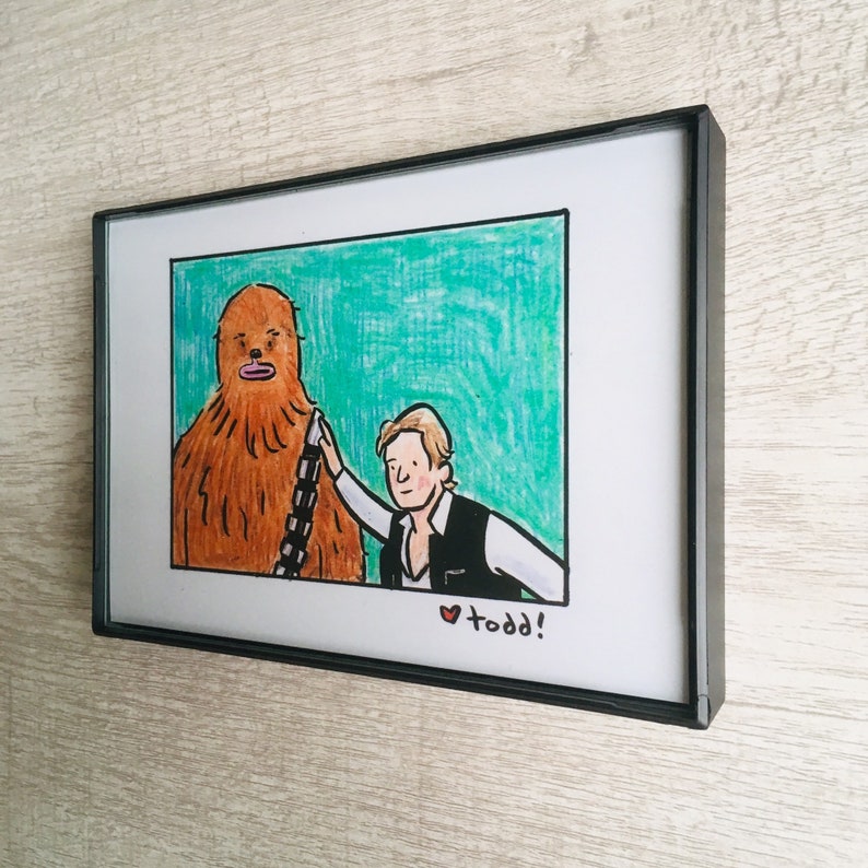 May include: A framed illustration of a brown Wookiee character from Star Wars with a human character standing next to it. The human character is wearing a brown vest and a white shirt. The background is a teal green color. The text "&hearts; todd!" is written at the bottom of the illustration.