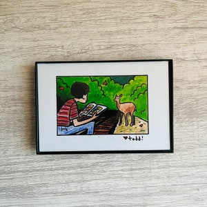 May include: A hand-drawn illustration of a person sitting in a forest reading a book. A small deer stands in the background. The illustration is signed "todd!" in the bottom right corner.