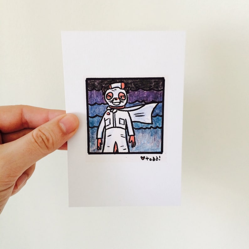 May include: A hand-drawn illustration of a cartoon character wearing a white mask and a white jumpsuit with a cape. The character is standing in front of a dark blue and purple background with waves. The illustration is signed "todd!" in the bottom right corner.
