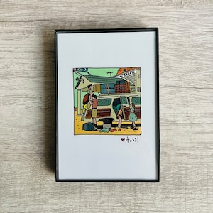 May include: Framed art print featuring a family loading a van with luggage. The illustration is in a cartoon style with a retro aesthetic. The van is brown and white, and the scene is set at a roadside diner. The word "GREASE" is visible.