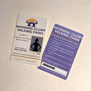 Könnte beinhalten: Zwei Mitarbeiterausweise von Morning Glory Milking Farm. Eine Karte zeigt das Firmenlogo, den Namen des Mitarbeiters, die Berufsbezeichnung und die ID-Nummer. Die andere Karte listet die Verhaltens- und Sicherheitsprotokolle der Mitarbeiter auf.