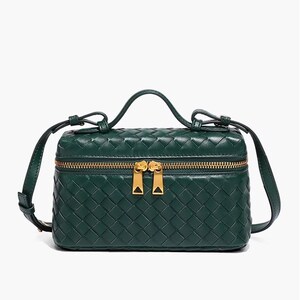 Puede incluir: Bolso de mano de cuero tejido verde oscuro de forma rectangular. El bolso tiene un asa superior, una correa ajustable y un cierre de cremallera dorado. El dise&ntilde;o incluye un patr&oacute;n tejido repetido. Mide aproximadamente 20 cm de largo.