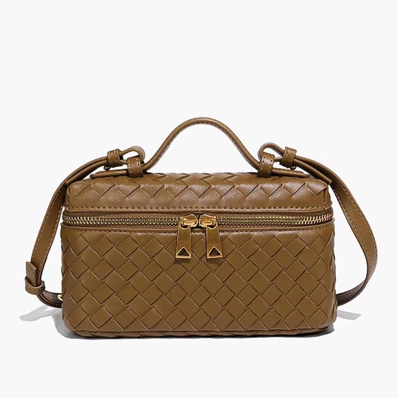 Puede incluir: Bolso de mano rectangular marr&oacute;n con un dise&ntilde;o tejido. El bolso tiene un asa superior y una correa de hombro larga y ajustable. Cuenta con un cierre de cremallera y herrajes dorados. El bolso tiene una forma estructurada.
