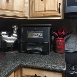 Farmhouse Bread Box Vegetable or Potato Bin. Great for storage that sits on the counter top. Has laser engraved. plexiglass in the doors with the top saying BREAD and bottom SNACKS.
Measures 16"h x !7"w x 11"d