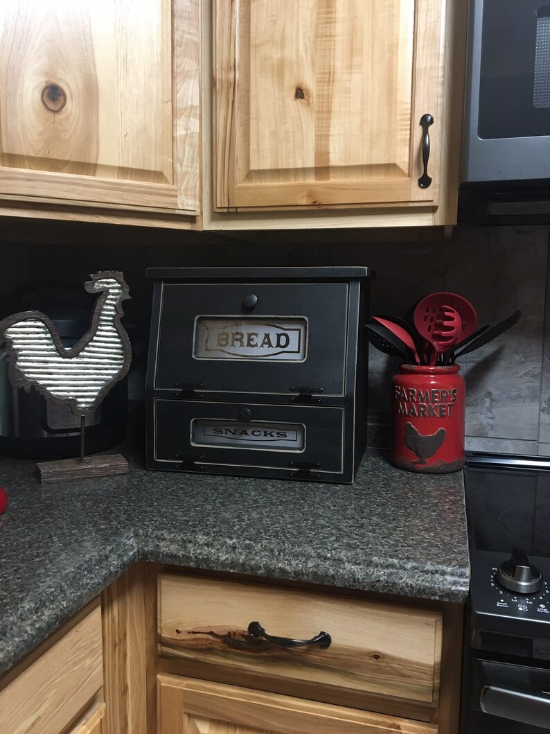 Farmhouse Bread Box Vegetable or Potato Bin. Great for storage that sits on the counter top. Has laser engraved. plexiglass in the doors with the top saying BREAD and bottom SNACKS.
Measures 16"h x !7"w x 11"d