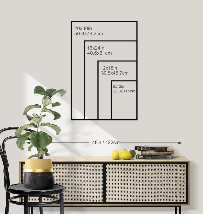 May include: A display of framed art prints in various sizes: 20x30in, 16x24in, 12x18in, and 8x12in. The image shows a black frame outline with the dimensions in inches and centimeters. The art is displayed above a wooden cabinet with a plant and fruit.