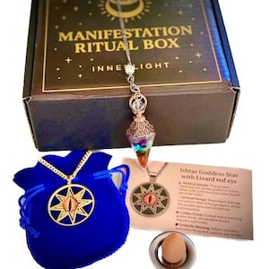 May include: A manifestation ritual box with a pendulum, a blue velvet bag with a gold star pendant, and a card with text. The box is brown with gold lettering. The pendulum has a crystal and metal design.