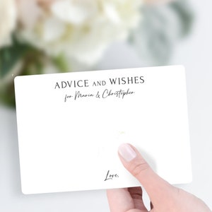 May include: White card with black text that reads "Advice and Wishes for Maria & Christopher" and "Love."