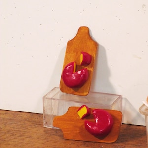 Miniature cheddar cheese wheel on cutting board