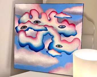 Könnte beinhalten: Ein Gemälde von Wolken mit darauf gemalten Augen. Die Wolken sind rosa, blau und weiß. Die Augen sind in verschiedenen Farben, darunter grün, blau und braun. Das Gemälde ist auf Leinwand und gerahmt.