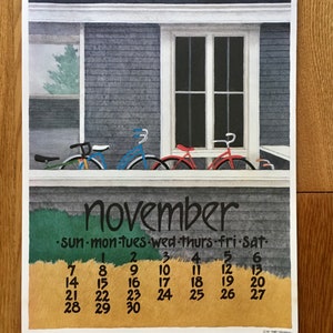 May include: A vintage calendar for November with a painted image of three bicycles parked in front of a gray house with a window. The calendar has the days of the week and numbers 1 through 30.