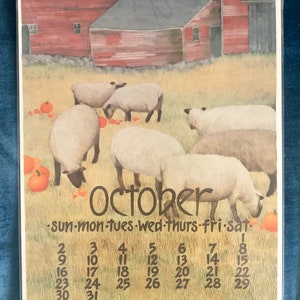 May include: A vintage calendar featuring a watercolor illustration of sheep in a field with a red barn in the background. The calendar is for October and includes the days of the week and dates.